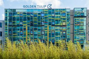 een gebouw met een bord aan de zijkant bij Golden Tulip Leiden Centre in Leiden