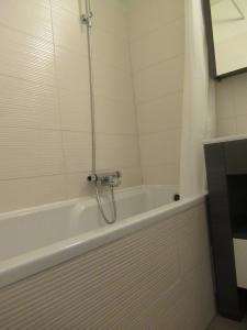 une baignoire blanche avec douche dans une salle de bain dans l'établissement Résidence Avenir 3 Valmeinier, à Valmeinier 6 autres photos