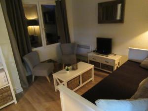 Elle comprend un petit salon doté d'un canapé et d'une télévision. dans l'établissement Résidence Avenir 3 Valmeinier, à Valmeinier