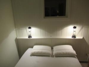 - un lit avec deux oreillers et deux lumières dans l'établissement Résidence Avenir 3 Valmeinier, à Valmeinier