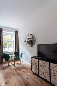 salon z telewizorem, stołem i krzesłami w obiekcie easy flat Sankt Elisabeth w Wiedniu