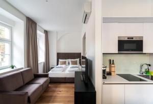 a room with a bed and a couch and a kitchen at easy flat Sankt Elisabeth in Vienna