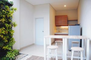 a kitchen with a counter and stools and a refrigerator at Rumah Mutiara in Bandung