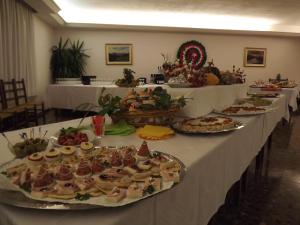 una fila de mesas llenas de diferentes tipos de alimentos en Albergo Ristorante Borghese, en Montereale Valcellina