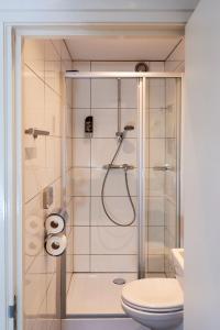 a bathroom with a shower with a toilet and a sink at ITC Hotel in Amsterdam