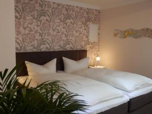 1 dormitorio con cama blanca y pared estampada en Design Apartments Bremen, en Bremen