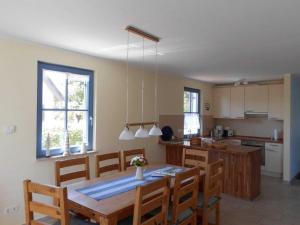 a kitchen and dining room with a table and chairs at Reetdachhaus Kranich in Mursewiek