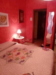 a bedroom with a bed and a red wall at Max House in Rome