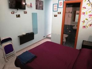 a bedroom with a purple bed and a bathroom at B&B Da Roberto in Naples
