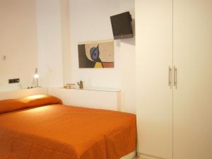 a bedroom with an orange bed and a cabinet at Marbel Apartments in Barcelona
