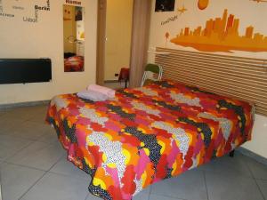 1 dormitorio con 1 cama con un edredón colorido en B&B Da Roberto, en Nápoles