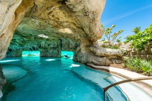 a swimming pool in a cave with blue water at Grand Hyatt Baha Mar in Nassau