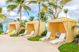 a row of beach huts with chairs and palm trees at Grand Hyatt Baha Mar in Nassau +136 photos