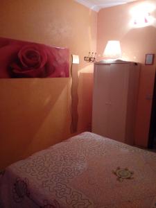 een slaapkamer met een bed met een rode roos aan de muur bij Max House in Rome