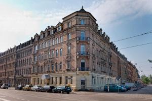 a large brick building with cars parked in front of it at ibis Styles Dresden Neustadt in Dresden