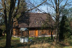 una casa de madera con árboles delante de ella en Pałacówka, en Dukla