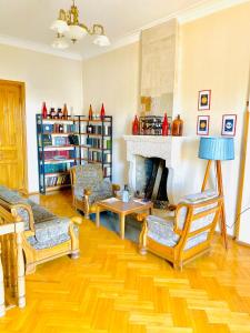 een woonkamer met 2 stoelen en een open haard bij Guesthouse Zedafoni in Zestafoni