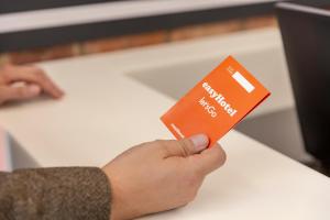 una persona que tenga una tarjeta de crédito frente a un mostrador en Easyhotel Reading en Reading