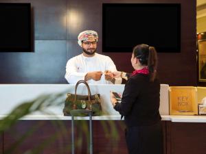 a man and woman standing next to each other at ibis Muscat in Muscat