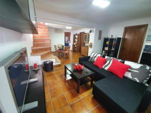 a living room with a black couch and a table at Villa Solojog23 in Arriate