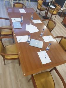 a wooden table with white papers and bottles on it at Hotel Elite Palermo Centro in Palermo