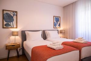 twee bedden in een hotelkamer met handdoeken op de bedden bij Toi et Moi-Guests speek for us! in Ponta Delgada