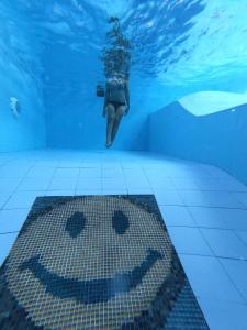 a woman swimming in a swimming pool with a sign under water at Blue Coco in Keramas