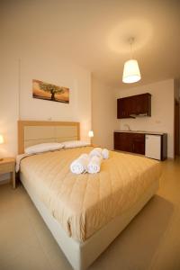 une chambre avec un grand lit avec des serviettes dessus dans l'établissement Alexander's House, à Parga