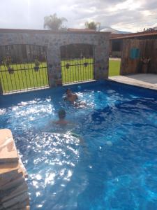2 personas nadando en una gran piscina azul en Hotel Boutique Rincon Sagrado, en Atlixco