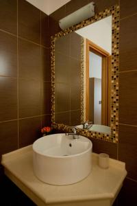 une salle de bains avec un lavabo blanc et un miroir dans l'établissement Alexander's House, à Parga