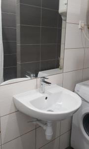 a bathroom with a white sink and a mirror at Arena Studio in Gliwice