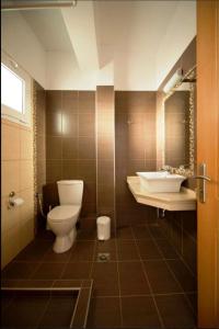 une salle de bains avec toilettes et lavabo dans l'établissement Alexander's House, à Parga