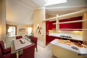 a kitchen and dining room with red cabinets and a table at Alp Apartments SKI & BIKE - Stevenin11 in Aosta