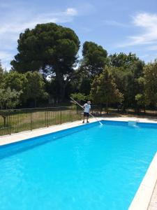 a person holding a rope in a blue pool at le Gecko en Provence in La Roque-sur-Pernes