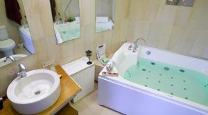 a bathroom with a sink and a tub and a toilet at Casa Rural Lakoak in Garínoain