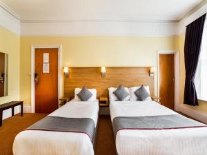 Un pat sau paturi într-o cameră la OYO Eagle House Hotel, St Leonards Hastings