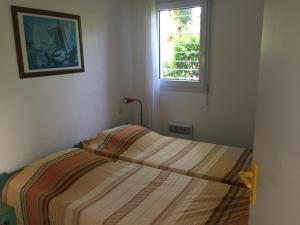 サン・シプリアンにあるVilla 33 résidence Les Pierres de Jadeの小さなベッドルーム(ストライプ毛布付きのベッド付)