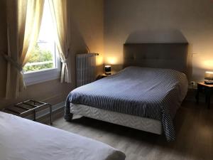 ein Schlafzimmer mit zwei Betten und einem Fenster in der Unterkunft Hôtel l'Annexe in Moux-en-Morvan