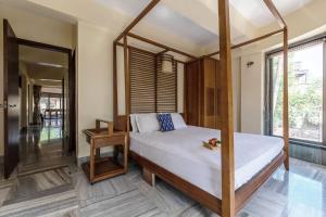 una camera con letto a baldacchino e finestra di The Boulevard by StayVista - A city-center villa boasting a private plunge pool, Jacuzzi & a revitalizing rain shower a Lonavala