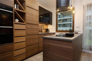a kitchen with wooden cabinets and a counter top at Apartments Rzeczypospolitej by Renters Prestige in Warsaw
