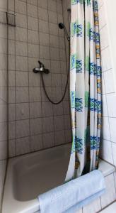 eine Badewanne mit Duschvorhang im Bad in der Unterkunft Ferienwohnungen Neue Tiefe - Wohnung Kleiderbügel in Neue Tiefe Fehmarn