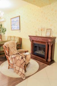 a living room with a fireplace and a chair at Erney Laz Hotel in Shaian
