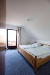 een slaapkamer met een houten bed en een raam bij Ferienwohnungen-Neue-Tiefe-Wohnung-Kleiderbuegel in Neue Tiefe Fehmarn