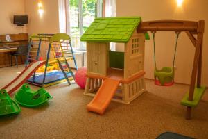una sala de juegos para niños con una casa de juguetes y un parque infantil en Erney Laz Hotel, en Shayan