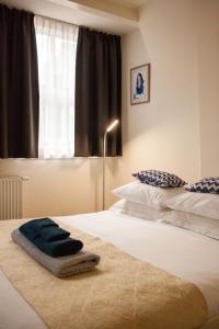 - une chambre avec 2 lits et une fenêtre dans l'établissement Kuwadro Guesthouse Jordaan, à Amsterdam