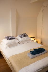 - un grand lit blanc avec 2 oreillers dans l'établissement Kuwadro Guesthouse Jordaan, à Amsterdam