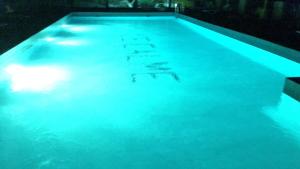 une piscine éclairée par des lumières bleues dans l'établissement Camping & Hôtel Le Calme, à Essaouira