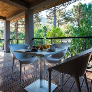 a dining room with a table and chairs on a deck at Hotel Restaurant Mariosa in Porto-Vecchio