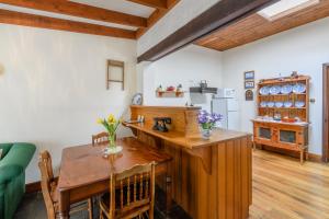 une cuisine avec une table en bois et une salle à manger dans l'établissement Bridge Cottage Sargeants & Armoury Cottages 1823, à Richmond