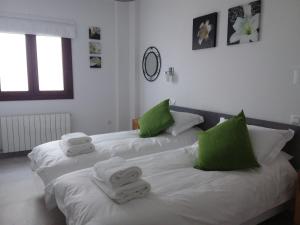 - 2 lits dans une chambre avec des serviettes vertes et blanches dans l'établissement Casa Clavero, à Ronda
